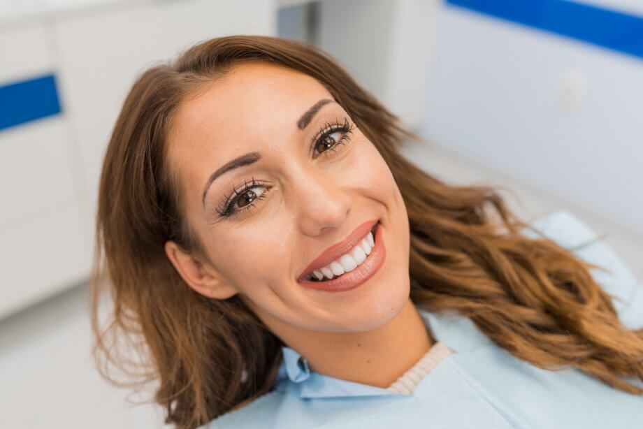 Young Woman with Brown Hair Smiling in Dental Chair