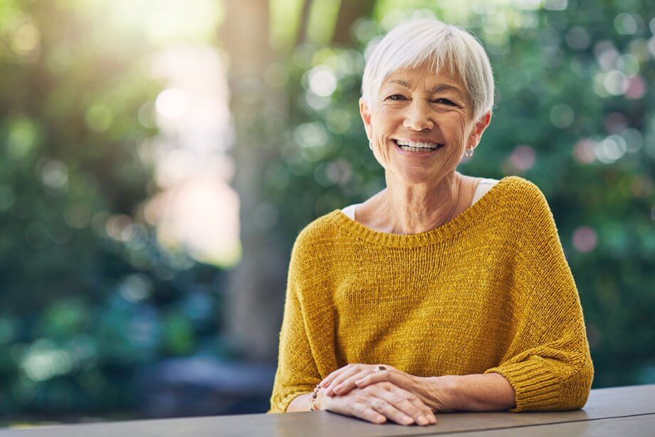 mature woman smiles outdoors