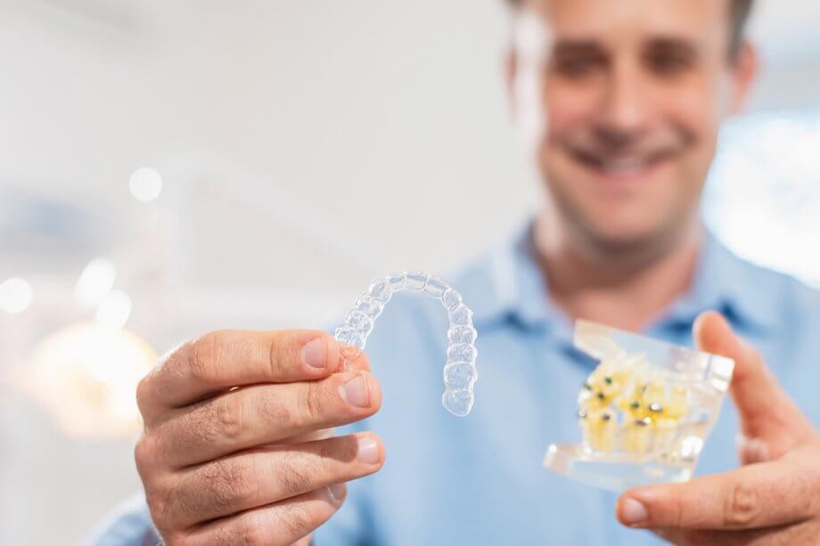 Man holding Invisalign tray