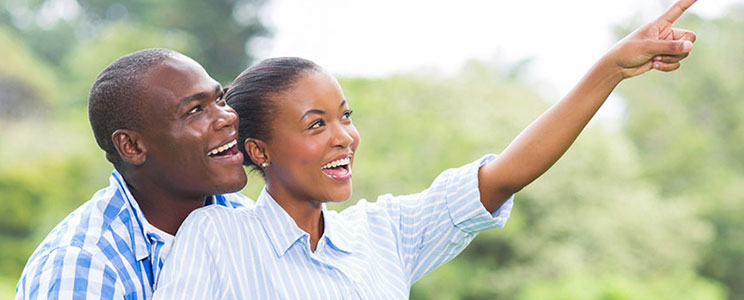 Smiling Couple Outside and Pointing at Nature