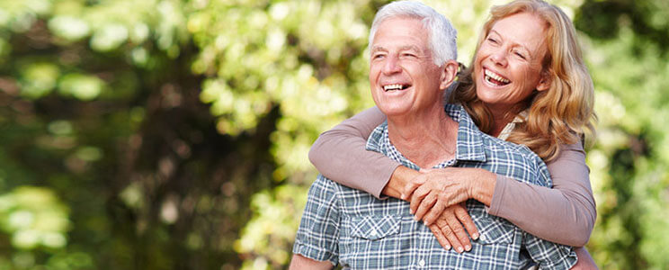 Happy Senior Couple Standing in the Woods