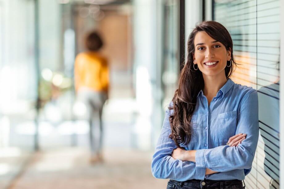 woman smiles in hallway of dental office